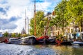 Waalseiland Canal with its historic canal houses, houseboats and commercial river boats in the old city center of Amsterdam Royalty Free Stock Photo