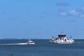 Waddensea, Netherlands-April 26,2021: The fast ferry and the car ferry boat with passengers sailing on Wadden Sea from Royalty Free Stock Photo