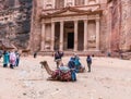 Camels are lying on the ground and are resting and waiting for tourists in the square in front of Al-Khazneh in Petra near Wadi Mu