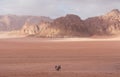 Wadi Rum desert landscape in Jordan with tourists riding camels in the morning Royalty Free Stock Photo