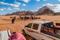 Wadi Rum desert, people, camels, cars at safari Royalty Free Stock Photo