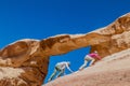 WADI RUM, JORDAN - MARCH 26, 2017: Tourists climbing to Burdah rock bridge in Wadi Rum desert, Jord Royalty Free Stock Photo