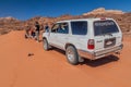 WADI RUM, JORDAN - MARCH 26, 2017: 4WD Toyota with tourists and a local Bedouin tour guide in Wadi Rum desert, Jord Royalty Free Stock Photo