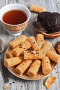 Wafer rolls, chocolate chip cookies and a cup of tea on a wooden table. Royalty Free Stock Photo