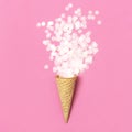 Waffle cone with bouquet of round confetti on pastel pink background. Festive holiday background, concept of party, birthday. Royalty Free Stock Photo