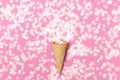 Waffle cone with bouquet of round confetti on pastel pink background. Festive holiday background, concept of party, birthday. Royalty Free Stock Photo