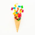 Waffle cone with colorful bright marmalade on white background. Flat lay, top view