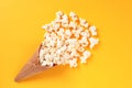 Waffle Cone with Salted Popcorn on yellow background. Snack concept