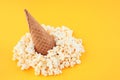 Waffle Cone with Salted Popcorn on yellow background. Snack concept