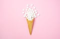 Waffle cone with white mini marshmallows on a pink background Royalty Free Stock Photo