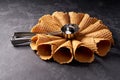 Waffle cones for ice cream and a spoon for it on black background, selective focus