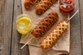 Waffle corn dogs on a wooden table