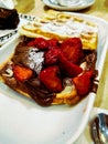 A waffle with strawberries, chocolate and sugar for the breakfast Royalty Free Stock Photo