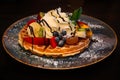 Waffle with fruits and whipped cream flavored with chocolate, dessert plate