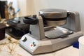 Waffle iron machine on the table in cafe kitchen Royalty Free Stock Photo