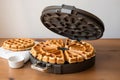 waffle iron opened, revealing perfectly cooked waffles