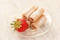 Waffle rolls with natural strawberry on glass plate