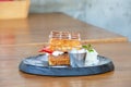 Waffle Strawerry fresh cream in the black plate on wooden table Royalty Free Stock Photo