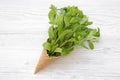 Waffle sweet ice cream cone with mint on white wooden table, from above. Top view Royalty Free Stock Photo