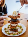 Waffle topped with cream and ice cream. chocolate, caramel and honey syrup with ice cream scoop fresh baked waffles