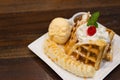 Waffle topped with ice cream , banana and wipe cream