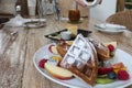 Waffle topped with mixed fruits, syrup, whipped cream, icing sugar and freshly chopped berries. Royalty Free Stock Photo