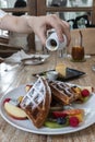 Waffle topped with mixed fruits, syrup, whipped cream, icing sugar and freshly chopped berries. Royalty Free Stock Photo