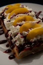 Waffle topped with whipped cream, sauce and fruit closeup Royalty Free Stock Photo