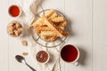 Waffle tubes with topping and tea on wooden white background