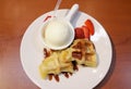 Waffle with vanilla ice cream topping and strawberry slice with chocolate sauce dessert served on white plate Royalty Free Stock Photo