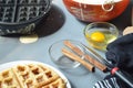 Waffle, waffle iron, bowl of batter, cinnamon sticks Royalty Free Stock Photo