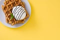 Waffles with chocolate sauce, ice cream and mint on yellow background Royalty Free Stock Photo