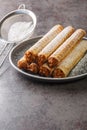 Waffles cones with boiled condensed milk in plate on table. Vertical Royalty Free Stock Photo