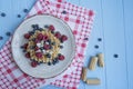 Waffles with fresh banana, raspberries, blueberries for breakfast. Belgian waffles. Light wooden background Royalty Free Stock Photo