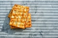 Waffles on kitchen marble countertop, morning breakfast, sunlight through blind