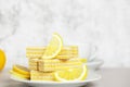 Waffles with lemon and milk filling. Lemon slices lying on saucer on blurred background. Yummy and sweet dessert. Bun-fight. Copy