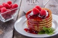 Waffles with raspberries and jam for breakfast on a wooden table