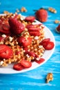 Waffles with strawberry on white plate on blue background. Royalty Free Stock Photo