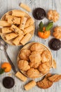 Waffles tubules and profiteroles on a rustic background. Chocolate biscuits and tangerines on a wooden light background. Royalty Free Stock Photo