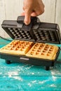 Waffles in waffle iron. Making waffles at home.