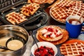 Waffles with whipped cream, berries and tea. Waffles are fried from dough in a waffle maker