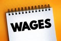 Wages - payment made by an employer to an employee for work done in a specific period of time, text concept on notepad