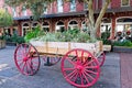 A Wagon wheel Cart sits outside filled with flowers Royalty Free Stock Photo