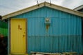 The number 14 in red on a rustic yellow boat shed door