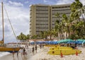 Waikiki, Honolulu, Hawaii - Oct 31, 2021-lifeguard surf boards, catamaran and umbrellas on the beach in front of high