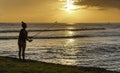 Waikiki, Honolulu, Hawaii - Oct 31, 2021-silhouette of person fishing from the beach at sunset