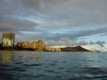 Waikiki Hotel building, clouds, and Diamond Head Crater in the distance on Oahu, Hawaii viewed from the water Royalty Free Stock Photo