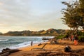 People enjoying the sunrise over the ocean on the beach of Wailua, Hawaii Royalty Free Stock Photo