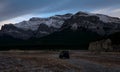 Black Jeep facing mountains and forestry