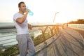 Waist length portrait of a handsome attractive middle aged Caucasian muscular build man, athlete drinking water after morning jog Royalty Free Stock Photo